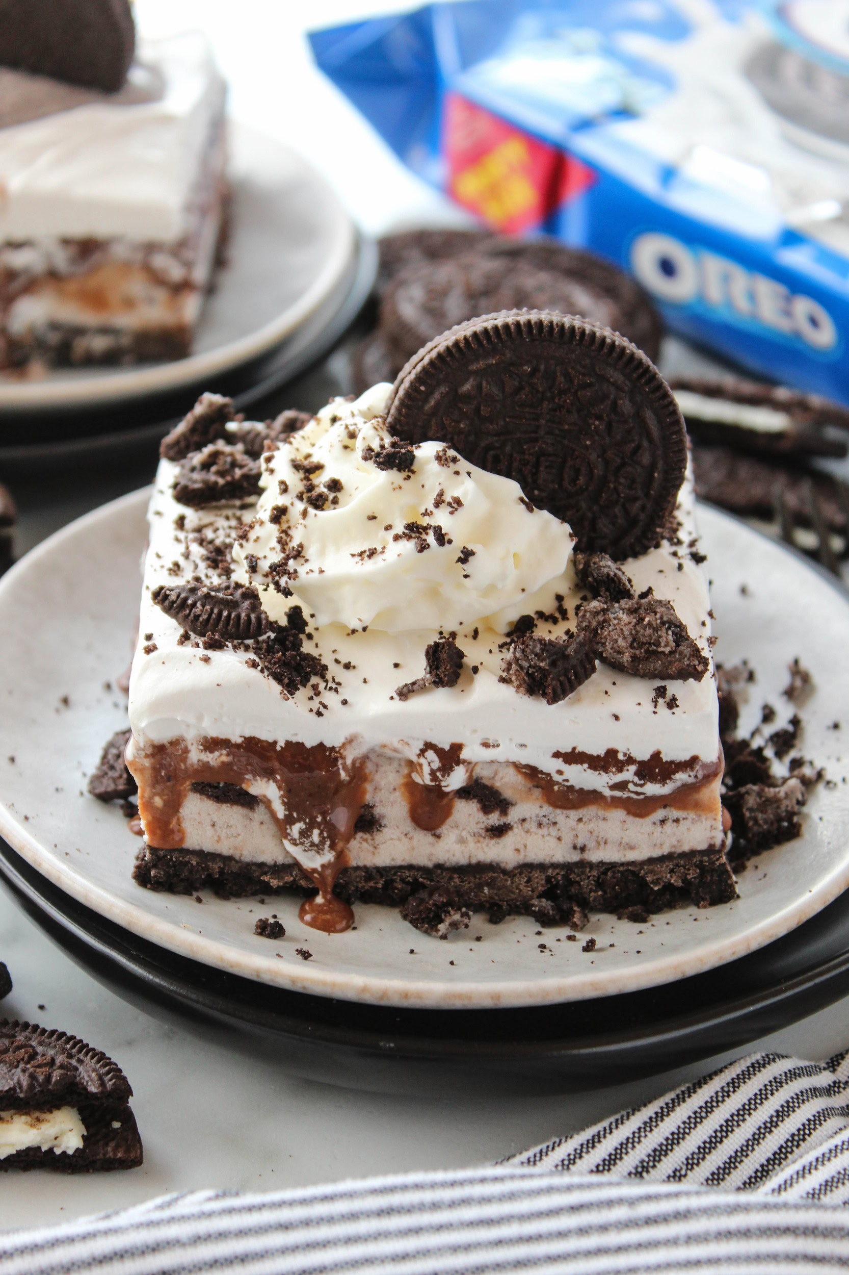 Frozen Oreo ice cream cake featuring cookies and cream ice cream, hot fudge, and an Oreo crust