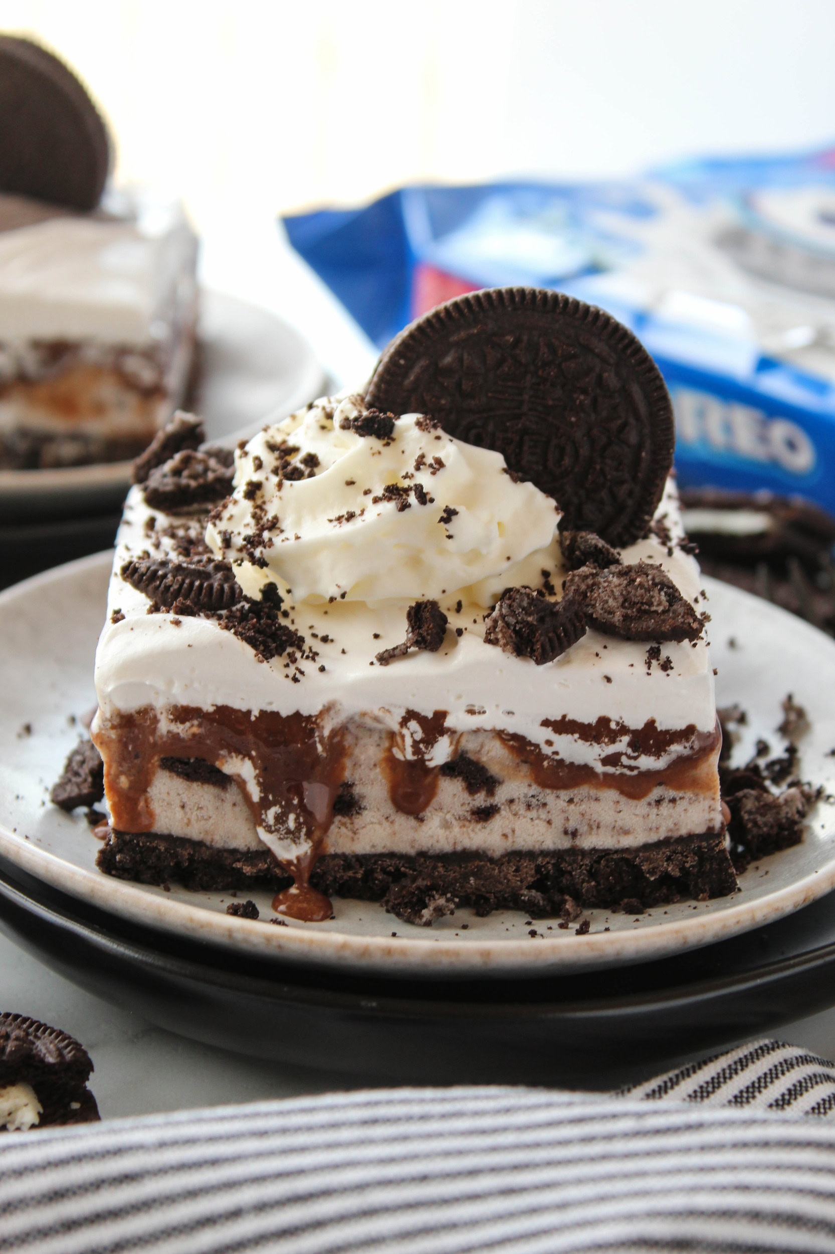No-bake Oreo ice cream cake decorated with Oreo cookie crumbs and whipped topping