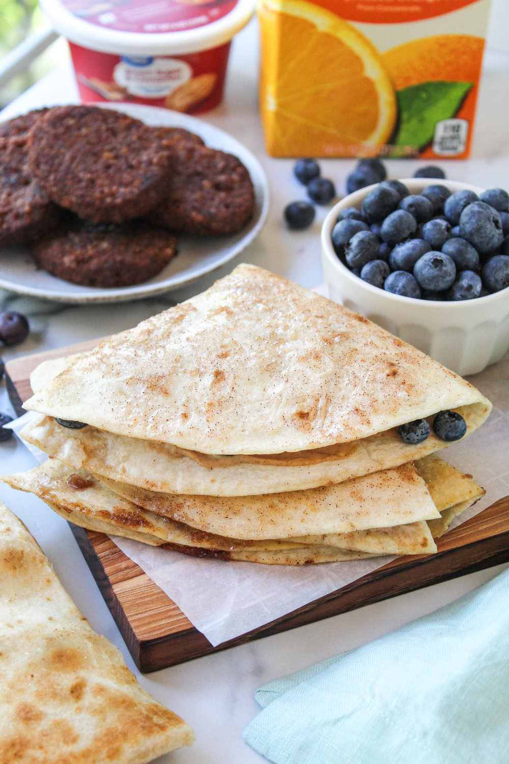 Blueberry breakfast quesadilla sliced into wedges on a white plate