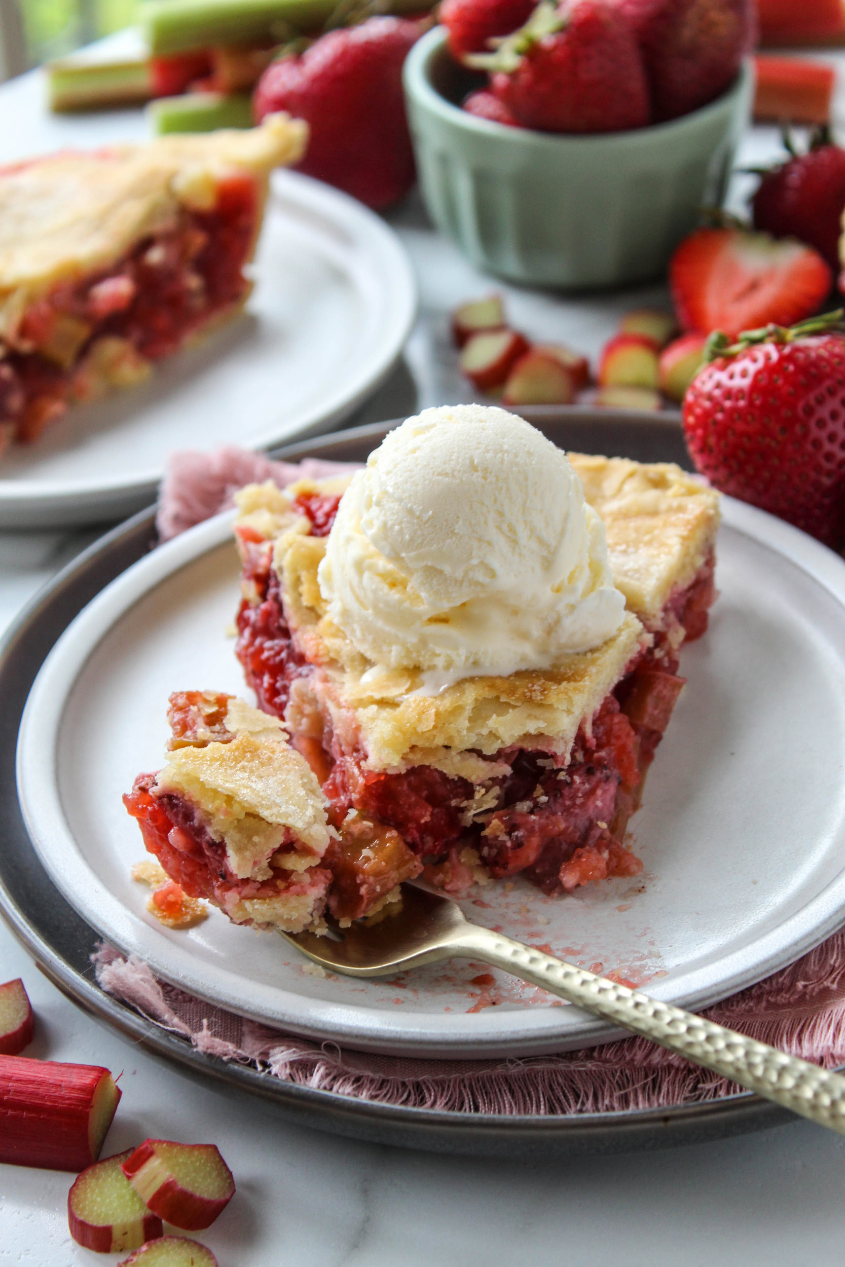 Slice of strawberry rhubarb pie showing thick, sweet‑tart filling and flaky crust