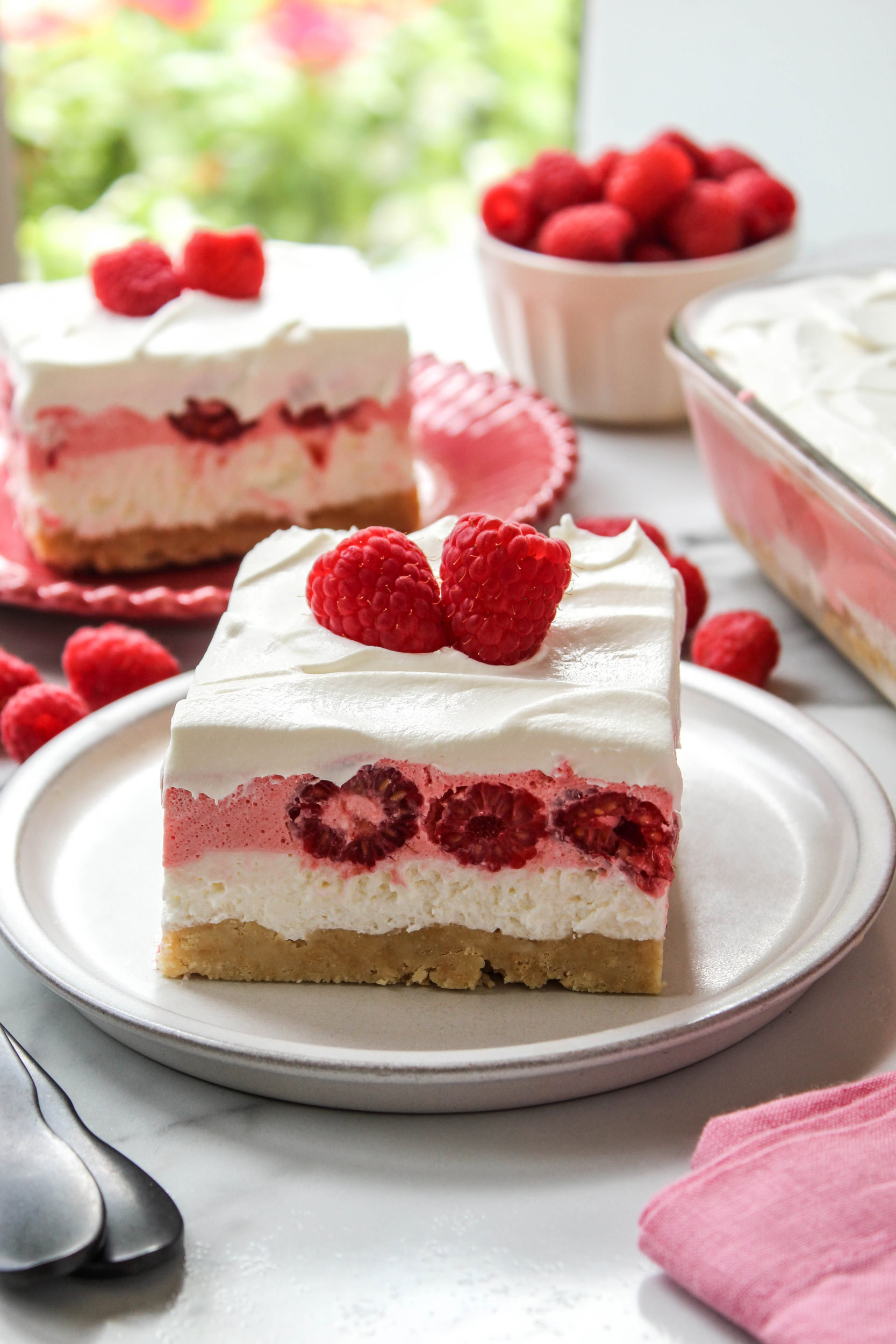Raspberry lasagna dessert layered with whipped topping and fresh raspberries