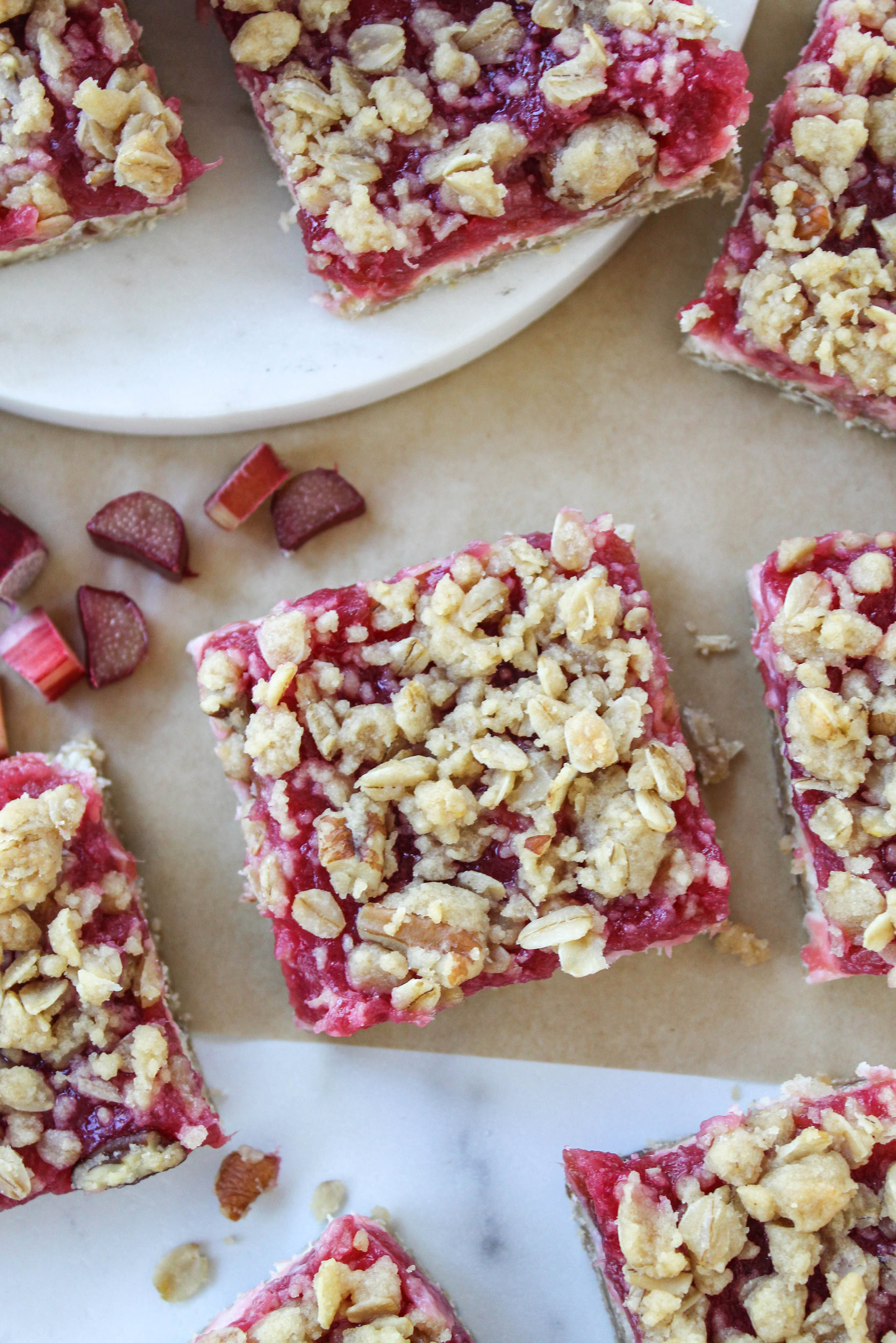 Easy rhubarb cheesecake bars with buttery crust and pink fruit topping