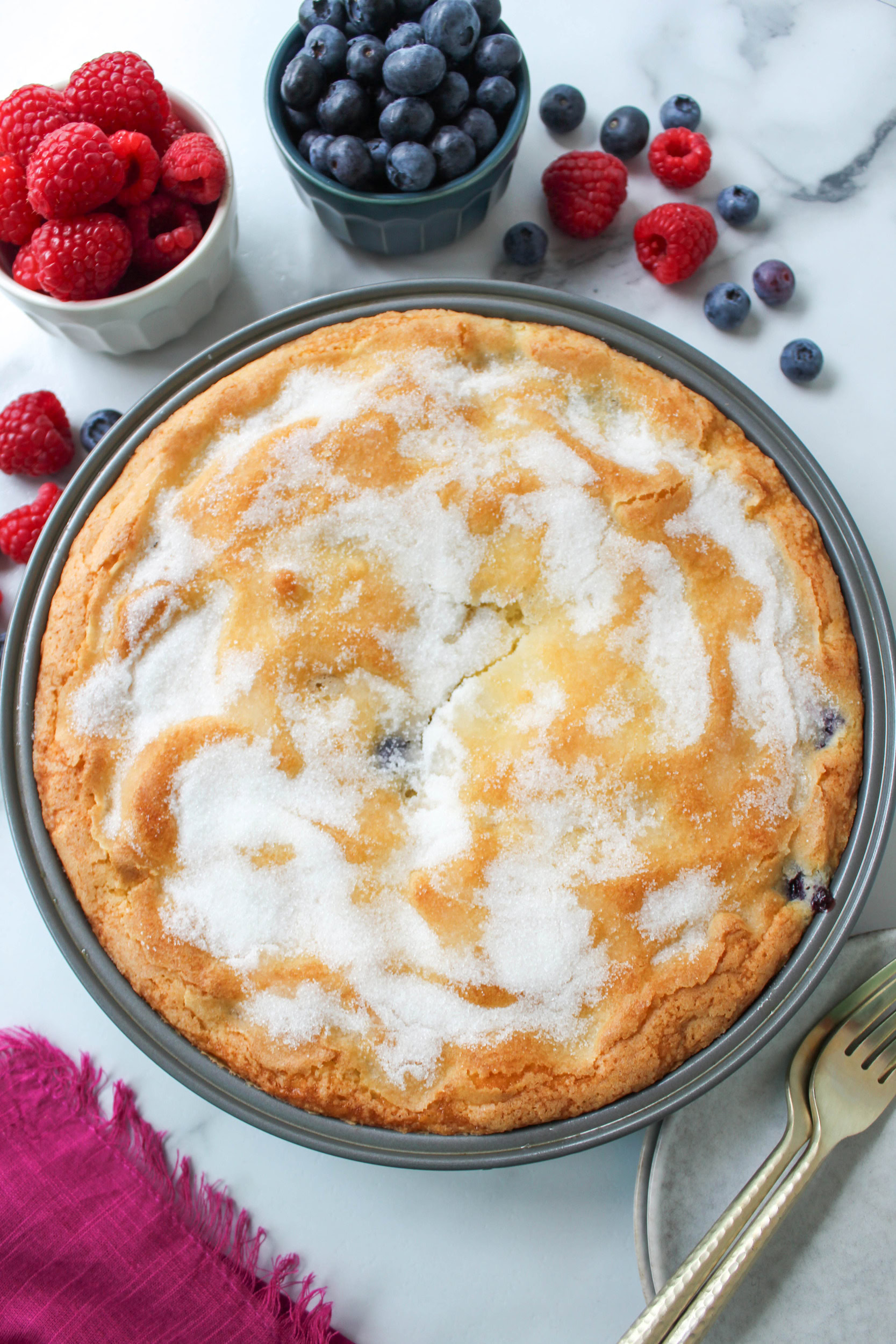 whole mixed berry cake with golden edges and juicy berries
