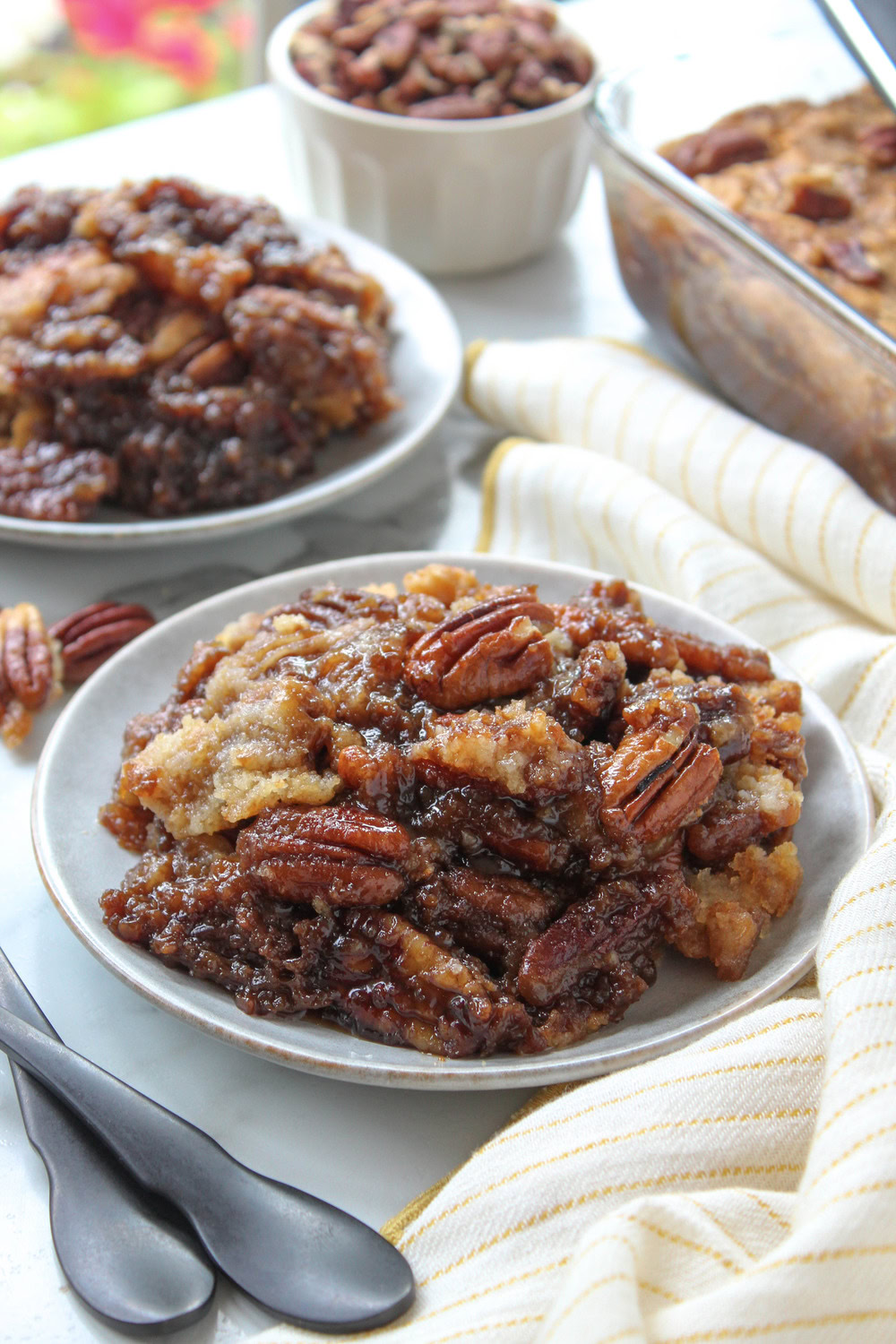 Gooey pecan pie dump cake with a golden cake topping and toasted pecans