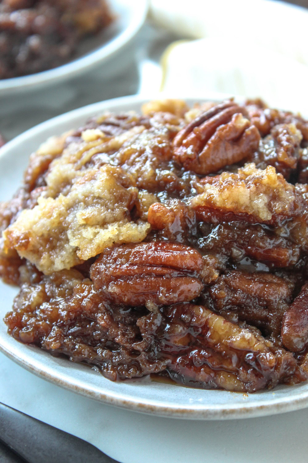 Warm pecan pie dump cake with caramelized pecans and buttery cake layer