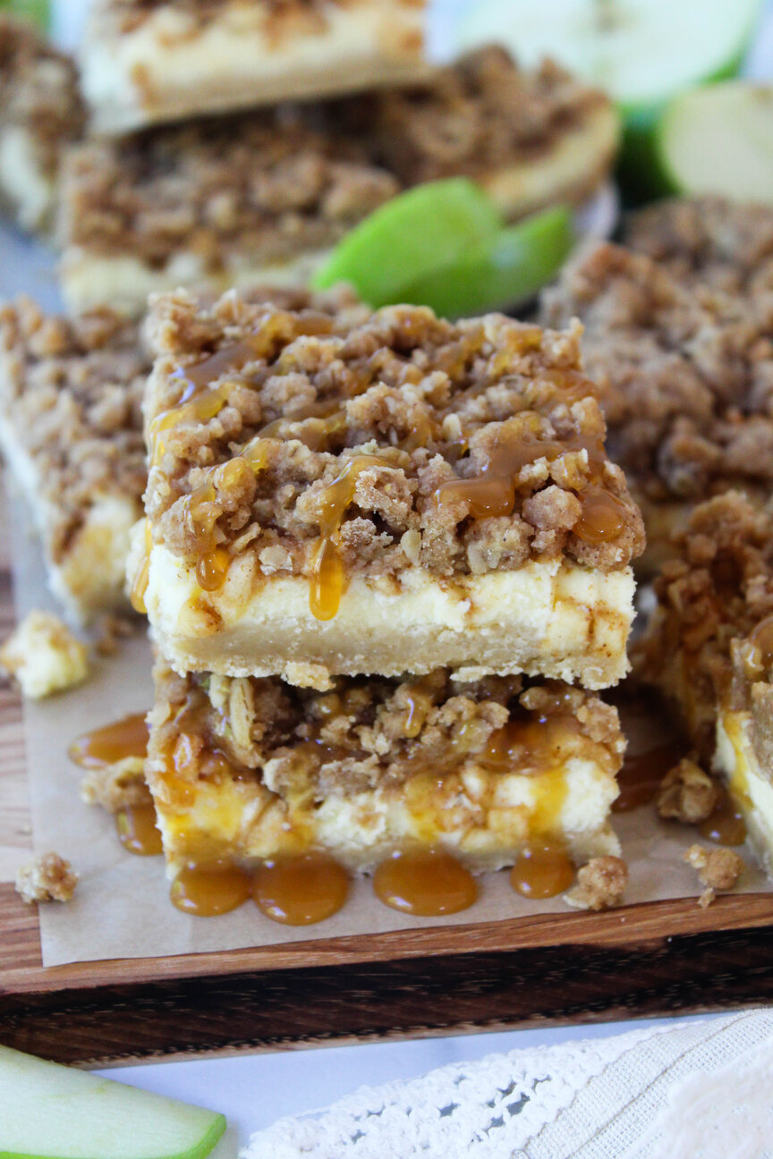 Caramel apple cheesecake bars drizzled with glossy caramel sauce