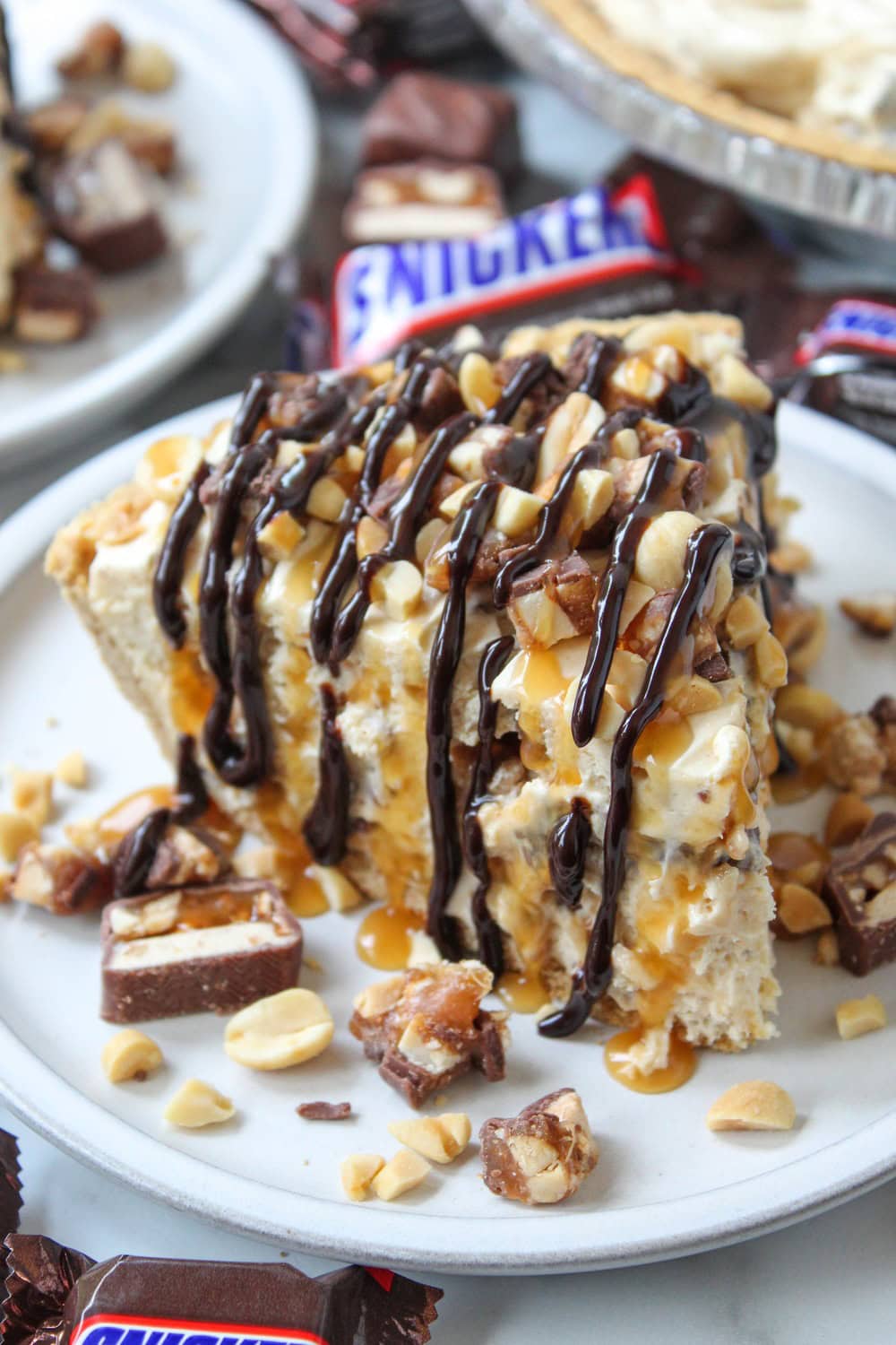 No-bake Snickers pie with a smooth peanut butter filling, chocolate topping, and caramel swirls