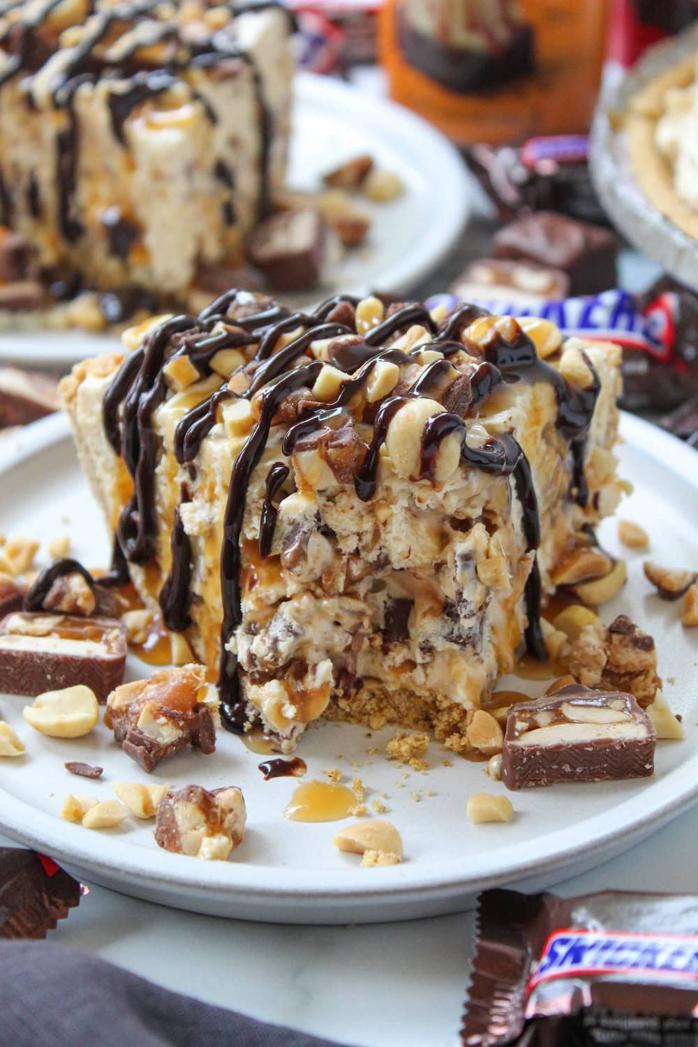 Graham cracker crust filled with fluffy Snickers-inspired cream and topped with chopped candy bars