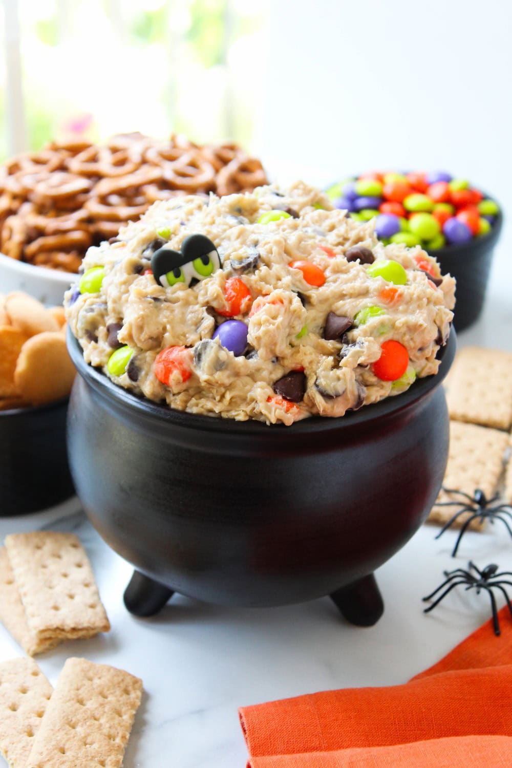 Creamy Halloween cookie dough dip served in a bowl with monster-themed decorations