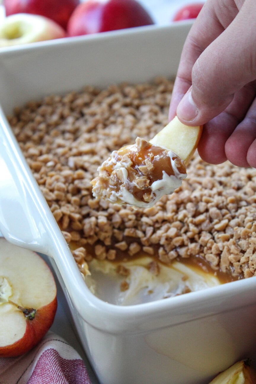 Caramel apple dip with a crunchy topping and apple slices ready for dipping