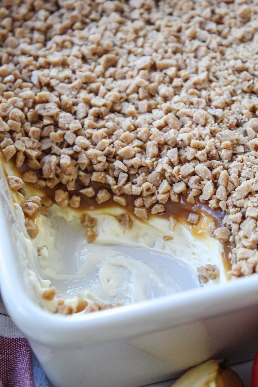 Caramel apple dip with layers of cream cheese, caramel, and toffee bits