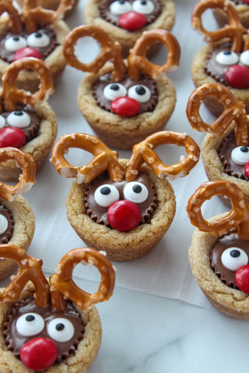 Reindeer peanut butter cup cookies with pretzel antlers and candy eyes