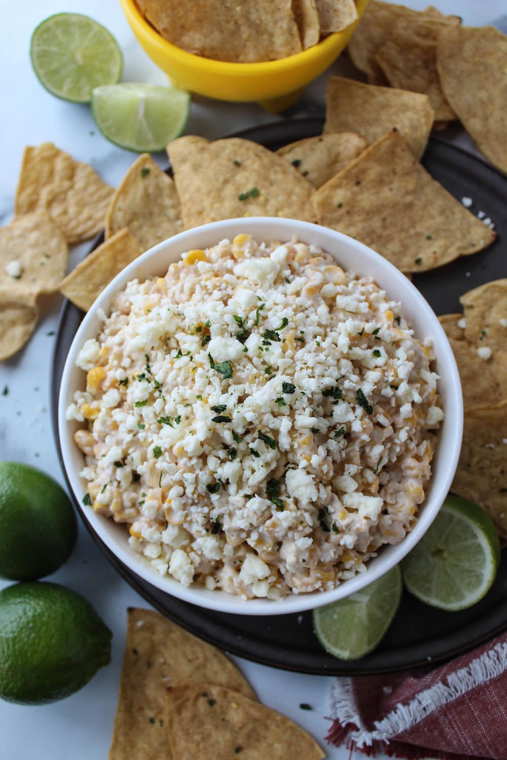Close‑up of Mexican street corn dip garnished with cotija cheese, chili powder, and cilantro