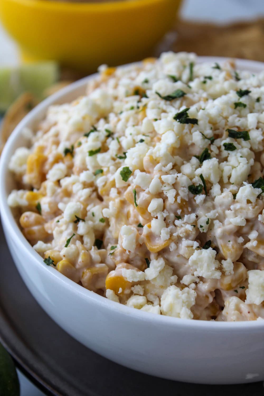 Bowl of Mexican street corn dip served warm with tortilla chips on the side