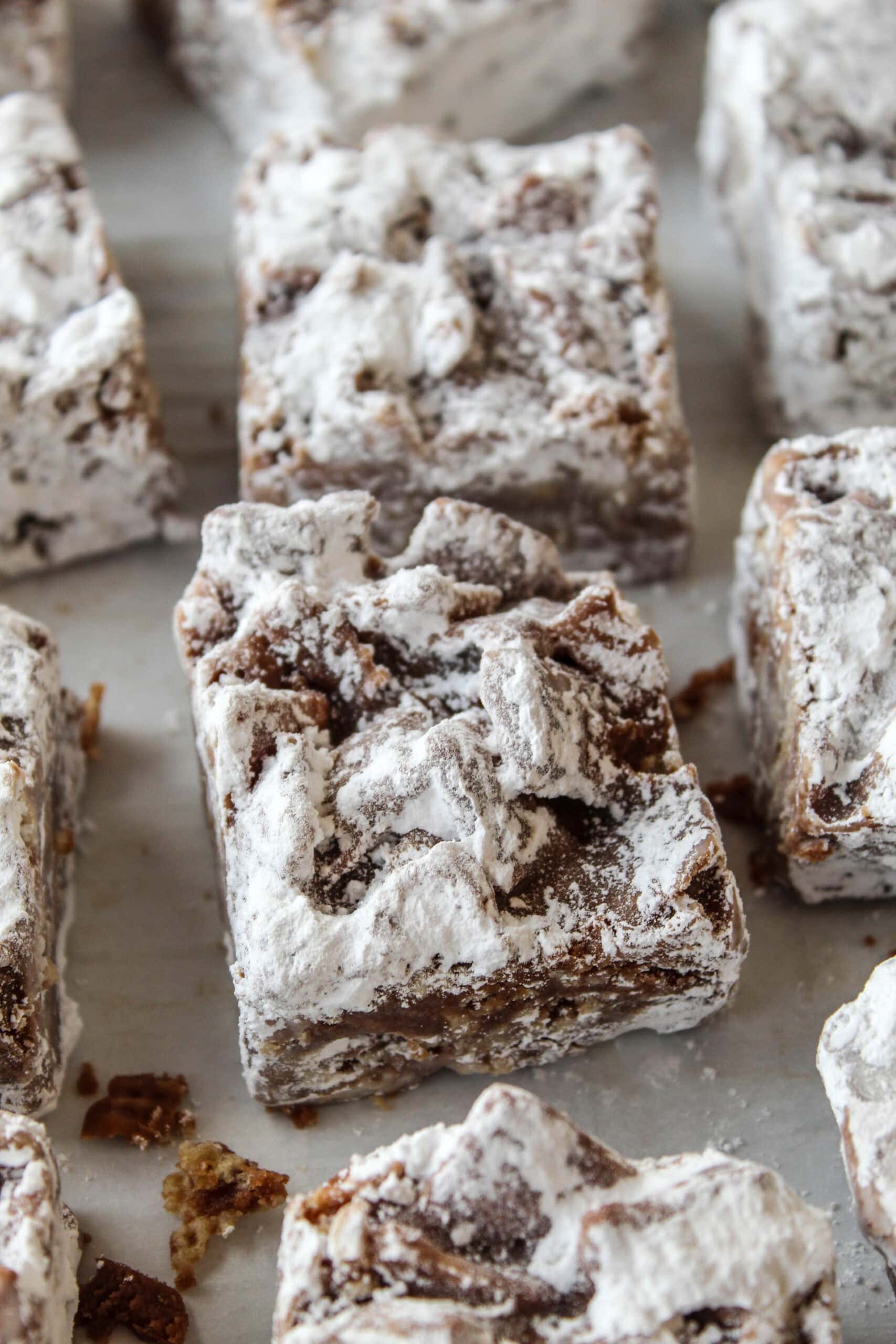 Puppy chow bars made with chocolate, peanut butter, Chex cereal, and powdered sugar