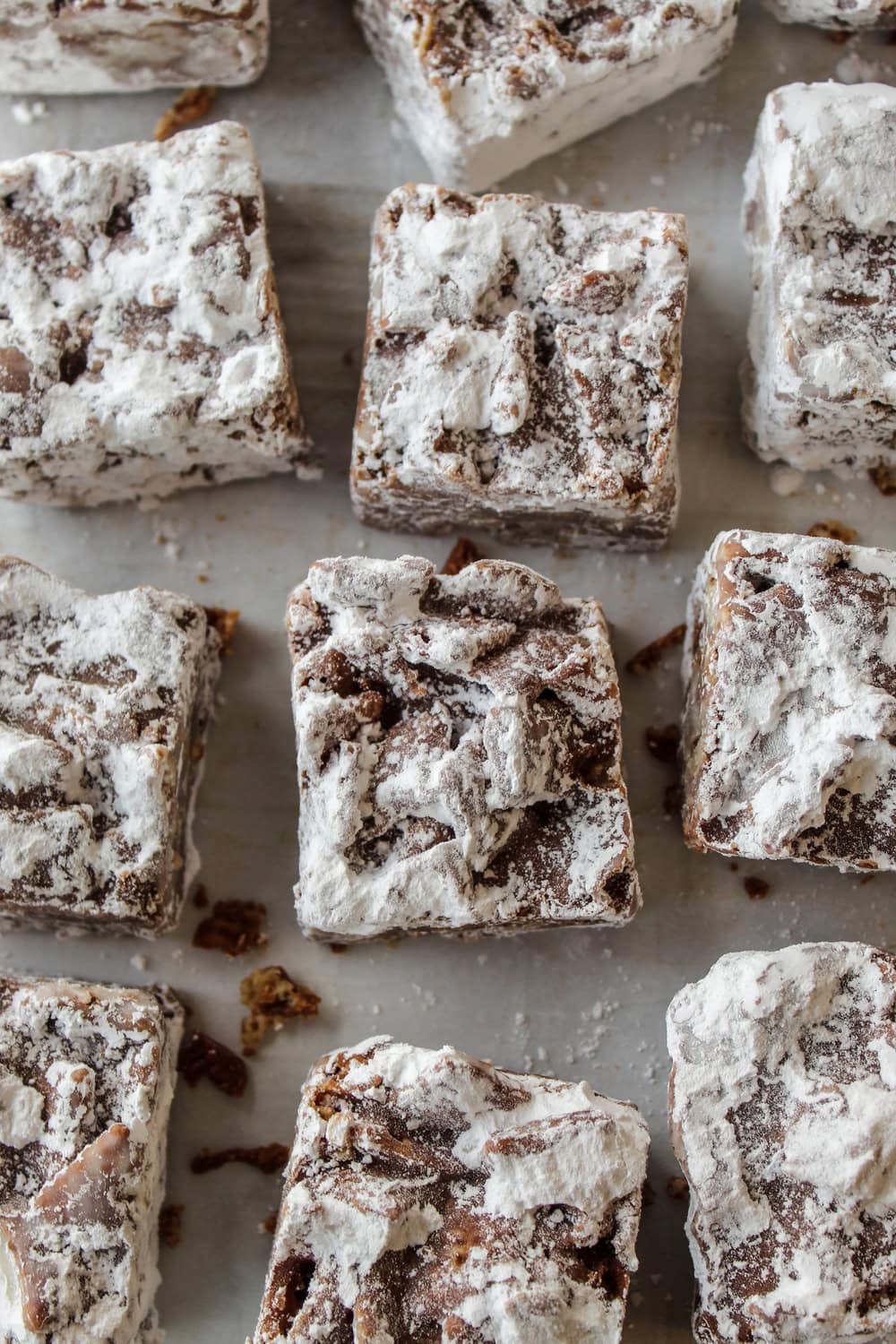 No‑bake puppy chow bars sliced into squares on parchment paper