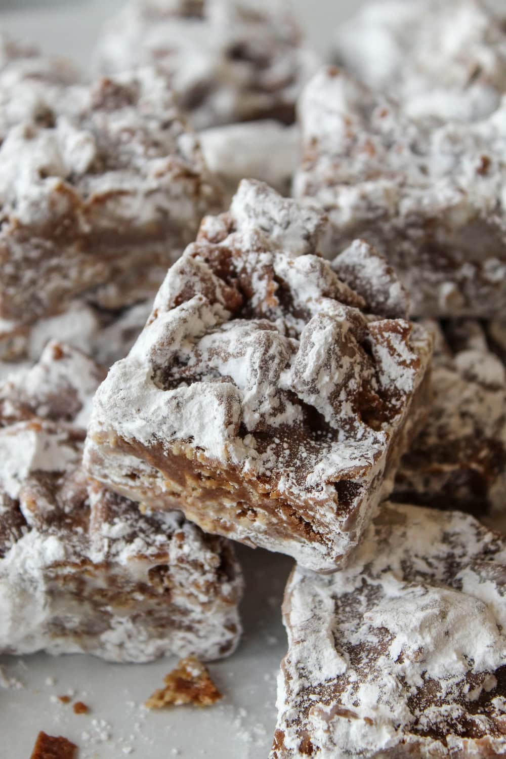 Chocolate peanut butter puppy chow bars with a powdered sugar coating