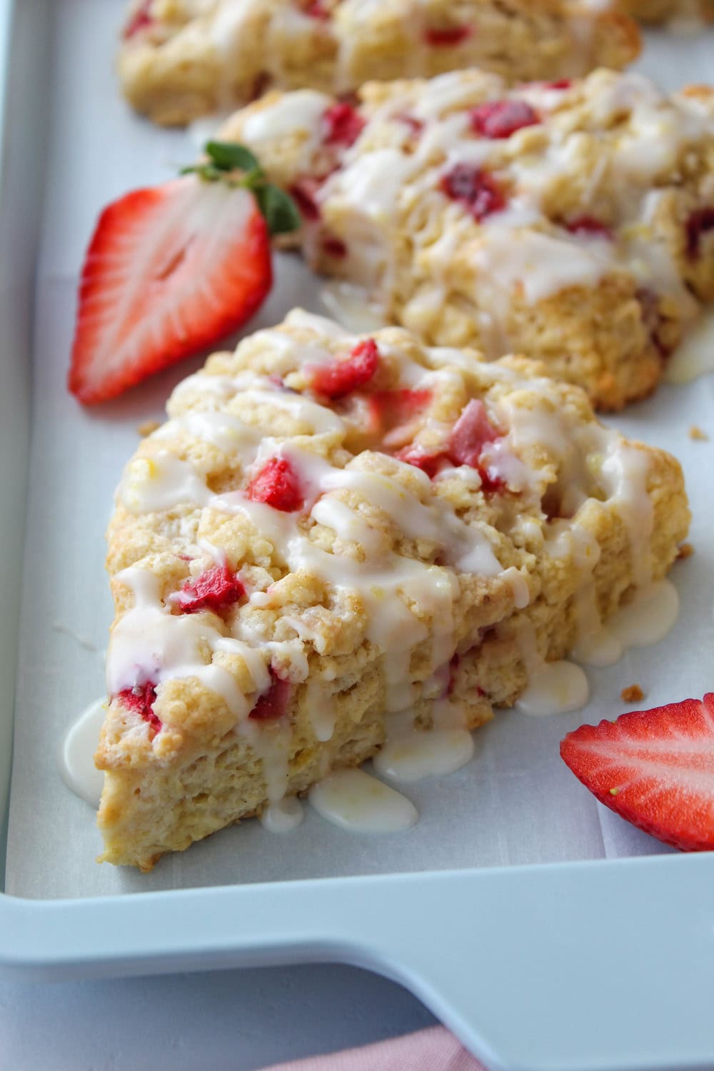Close‑up of soft strawberry lemon scones showing flaky crumb and glaze