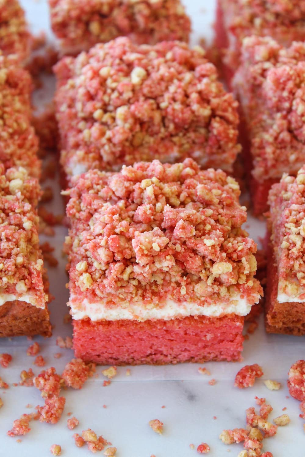 Strawberry crunch cheesecake brownies with a strawberry brownie base, creamy cheesecake layer, and crunchy strawberry topping