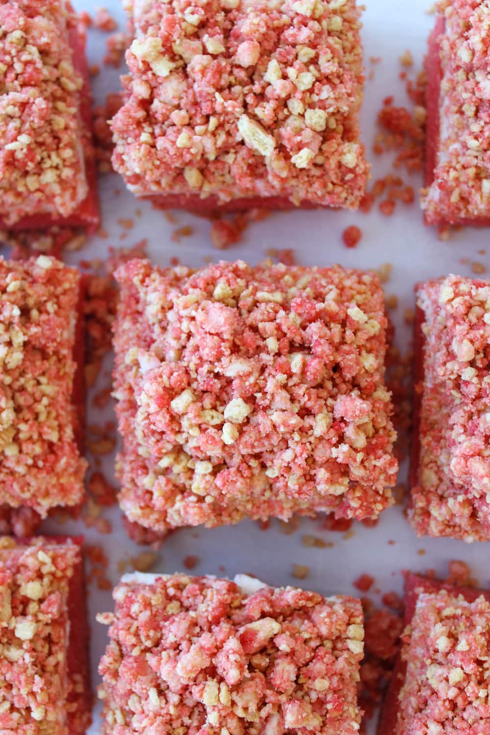 Sliced strawberry crunch cheesecake brownies stacked on a plate