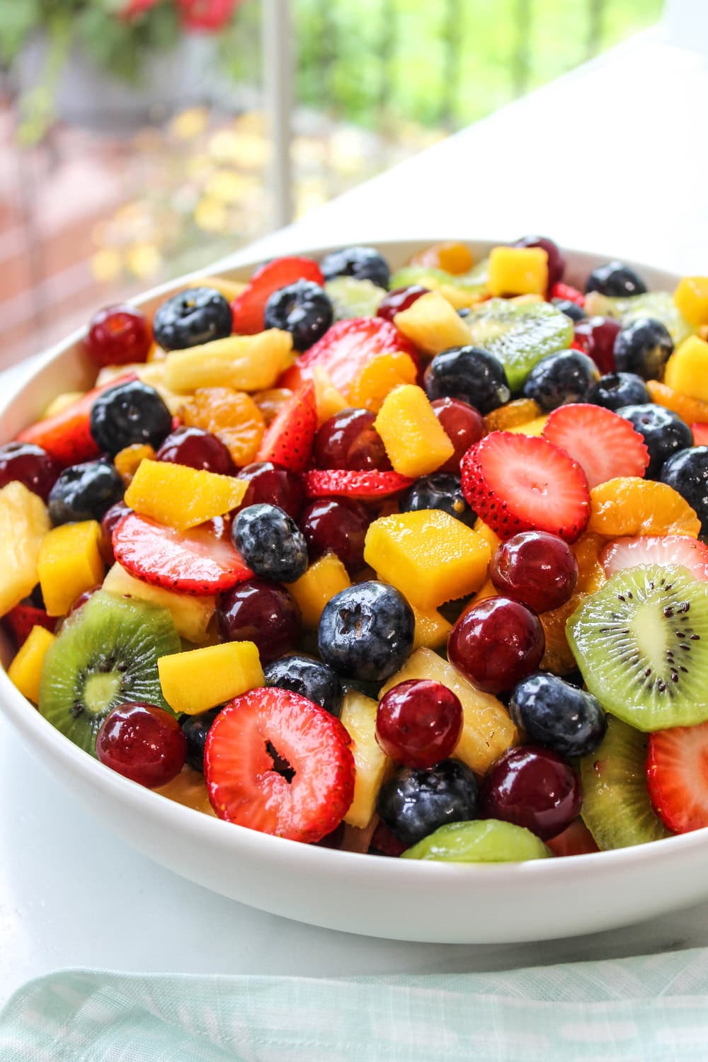 Fresh honey lime fruit salad with mixed berries and citrus in a bowl
