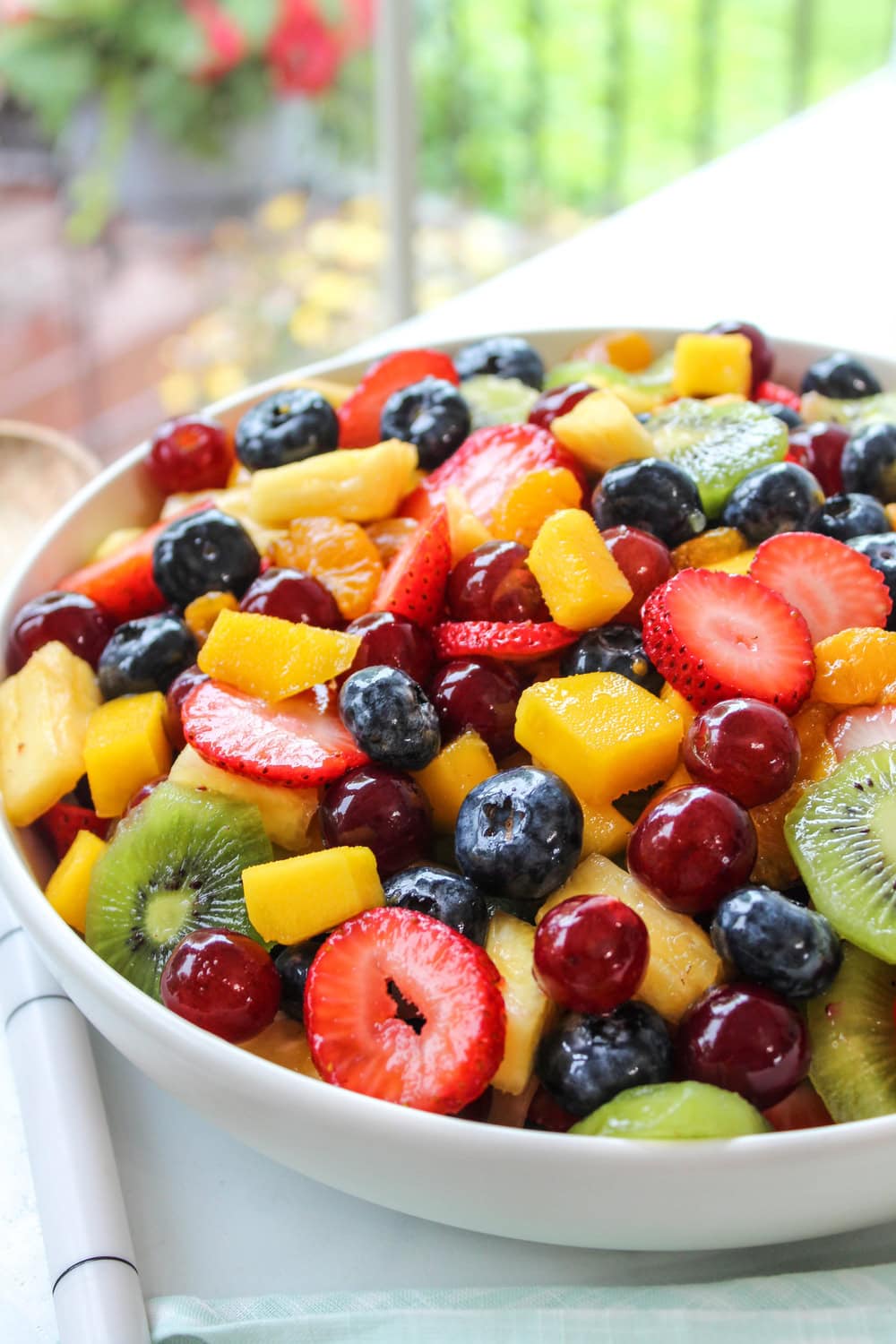 Healthy honey lime fruit salad with mango, kiwi, and berries