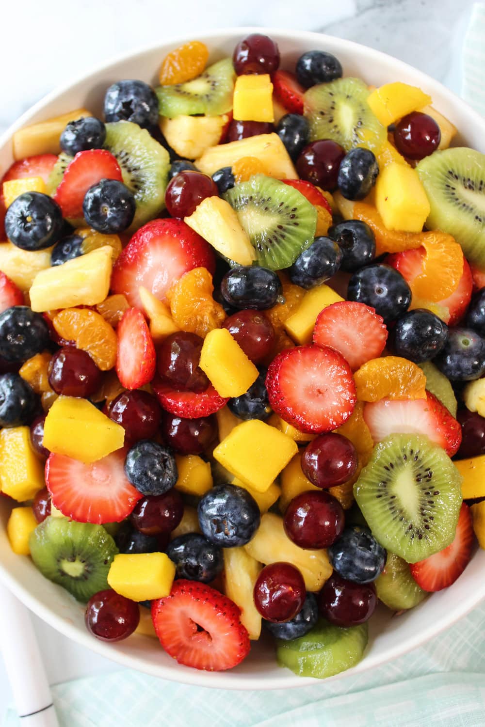 Colorful fruit salad tossed in honey lime dressing with strawberries, grapes, and pineapple