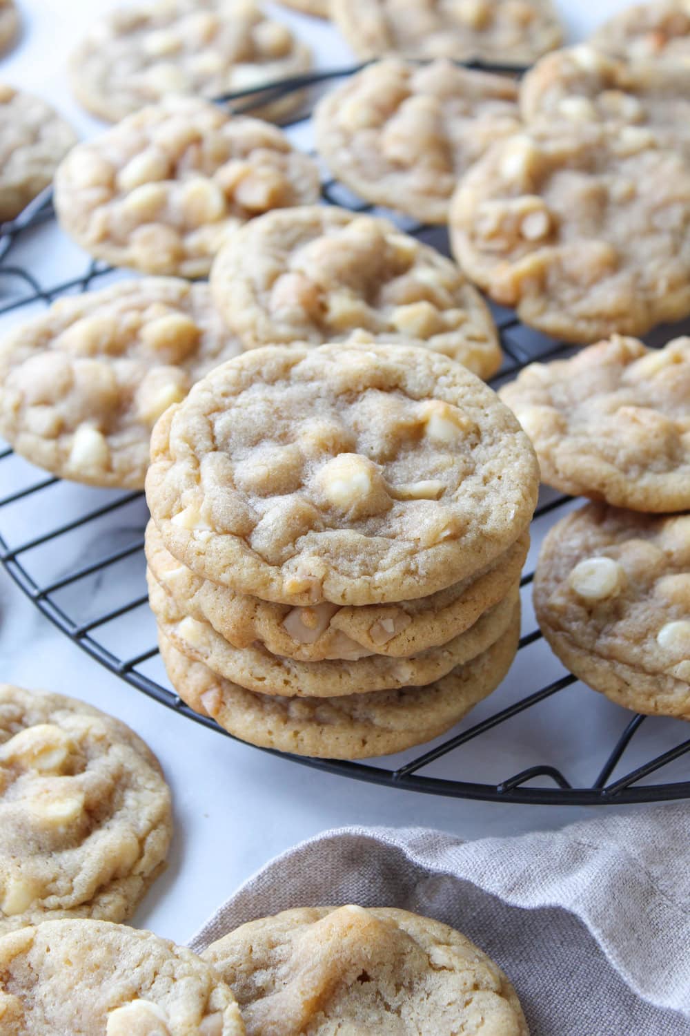 Stack of golden white chocolate macadamia cookies filled with crunchy macadamia nuts and melted white chocolate