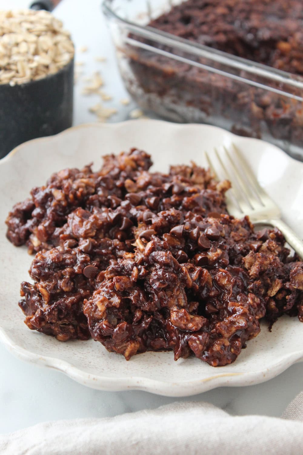 A rich, chocolate brownie baked oatmeal with a slightly cracked top and pockets of melted chocolate throughout