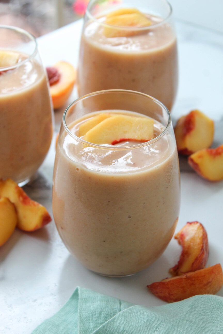Refreshing peach smoothie in a glass with straws, quick 5-minute recipe