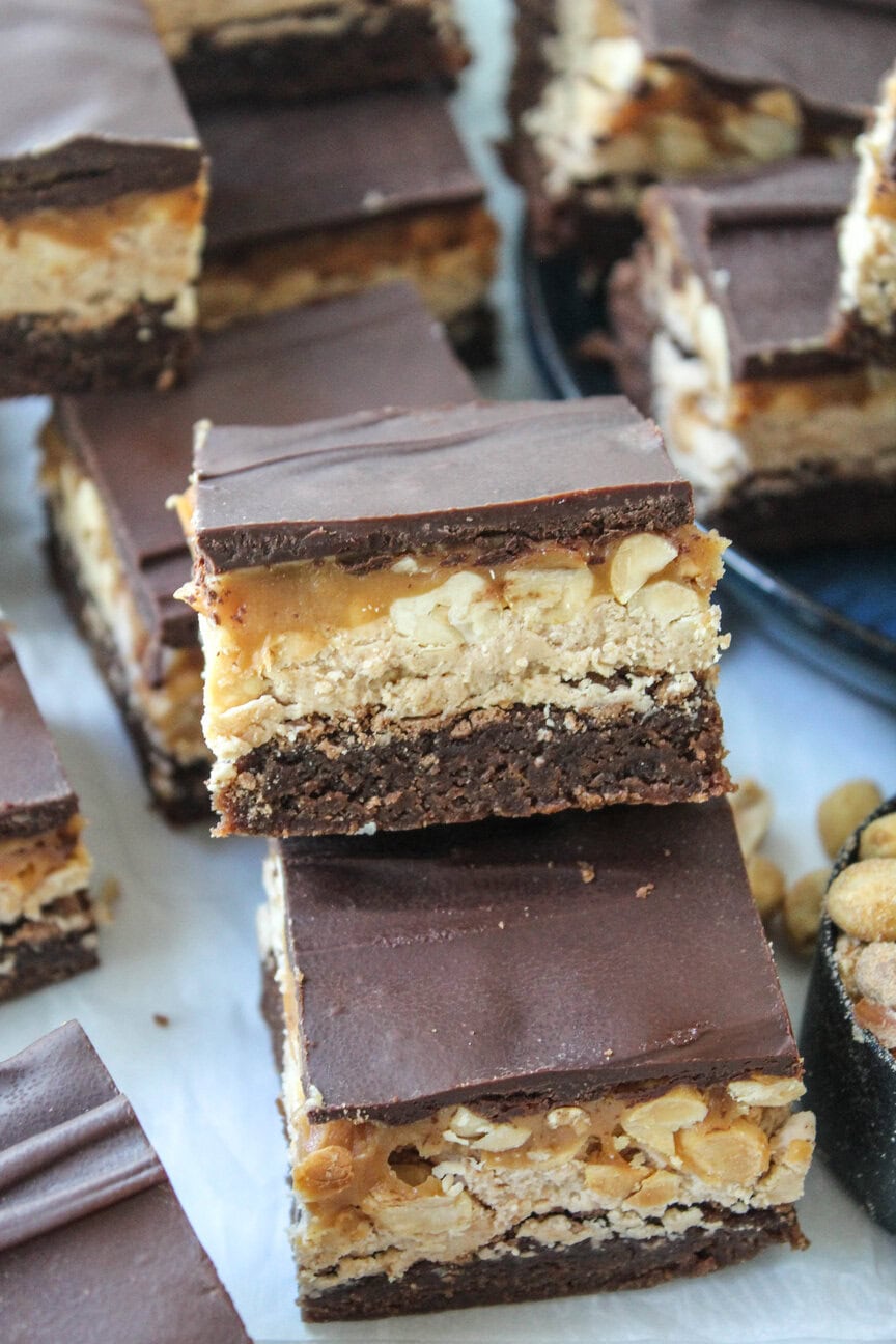 Close‑up of fudgy Snickers brownies showing thick nougat and caramel layers